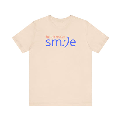 Beige t-shirt with 'be the reason smile' text on a white background